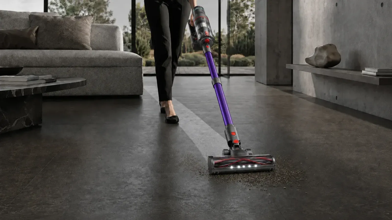 Mujer aspirando restos de un suelo oscuro con el Nexam V1 Pro, con el cepillo LED encendido